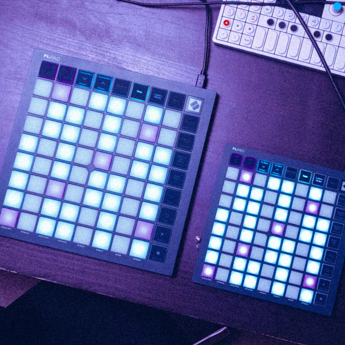 Novation FLpad and FLpad Mini side by side on a studio desk, RGB pads lit
