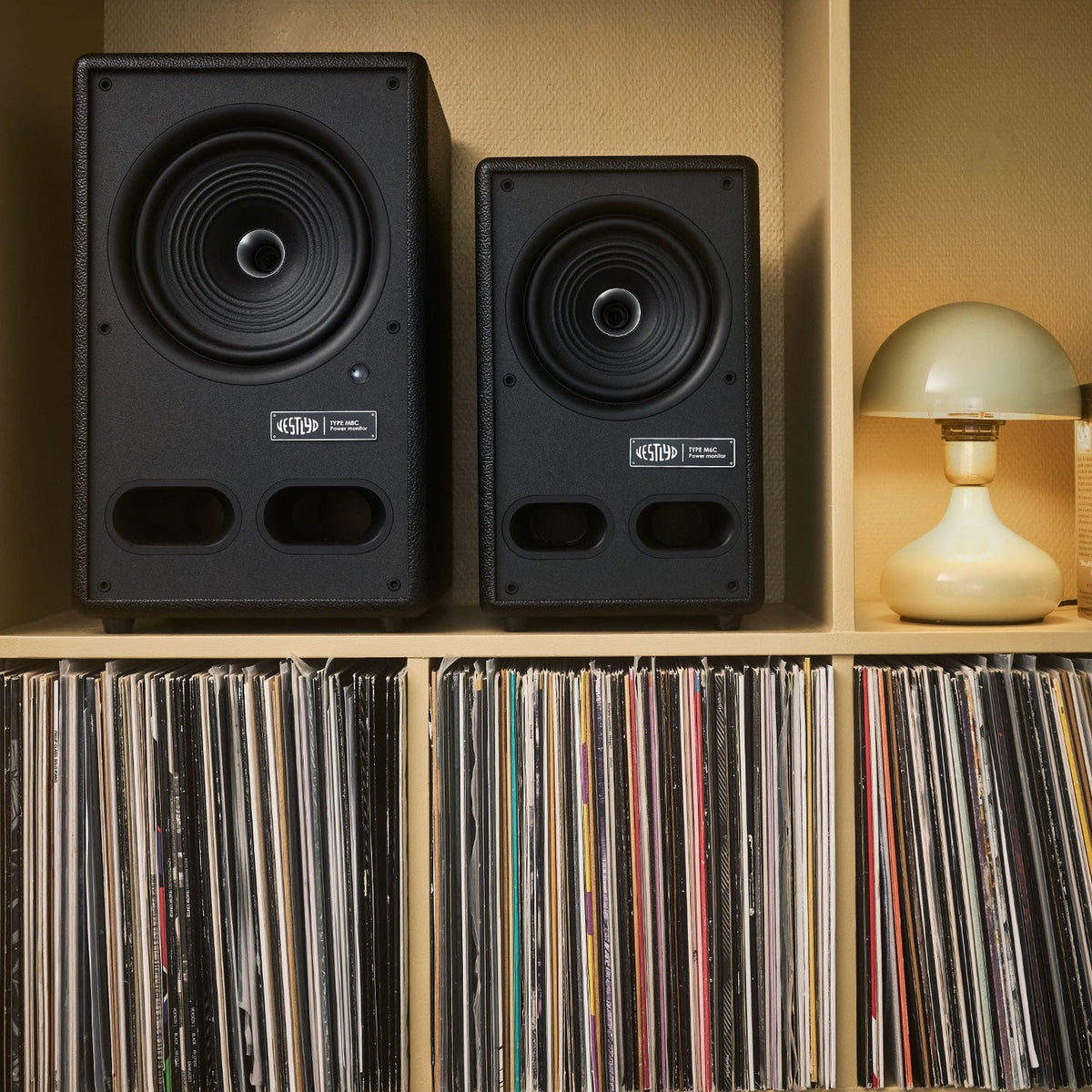 Vestlyd M8C Active and M6C Active in Black on a shelf above a record collection