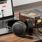 FiiO FT15 headphones on a desk with a laptop and headphone amplifier