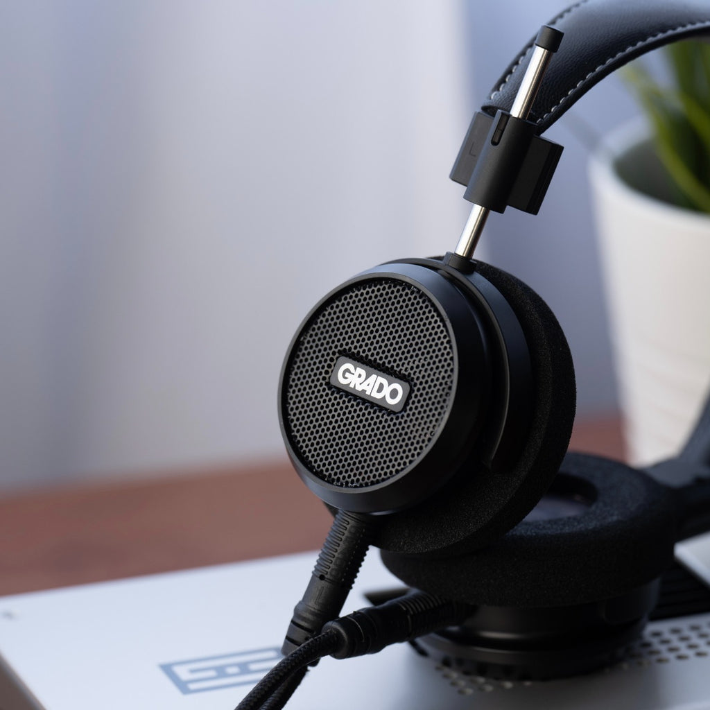 Grado Signature S150 headphones resting on a desktop DAC at home