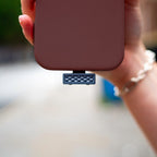 iFi Audio UP Play attached to the bottom of a phone outdoors